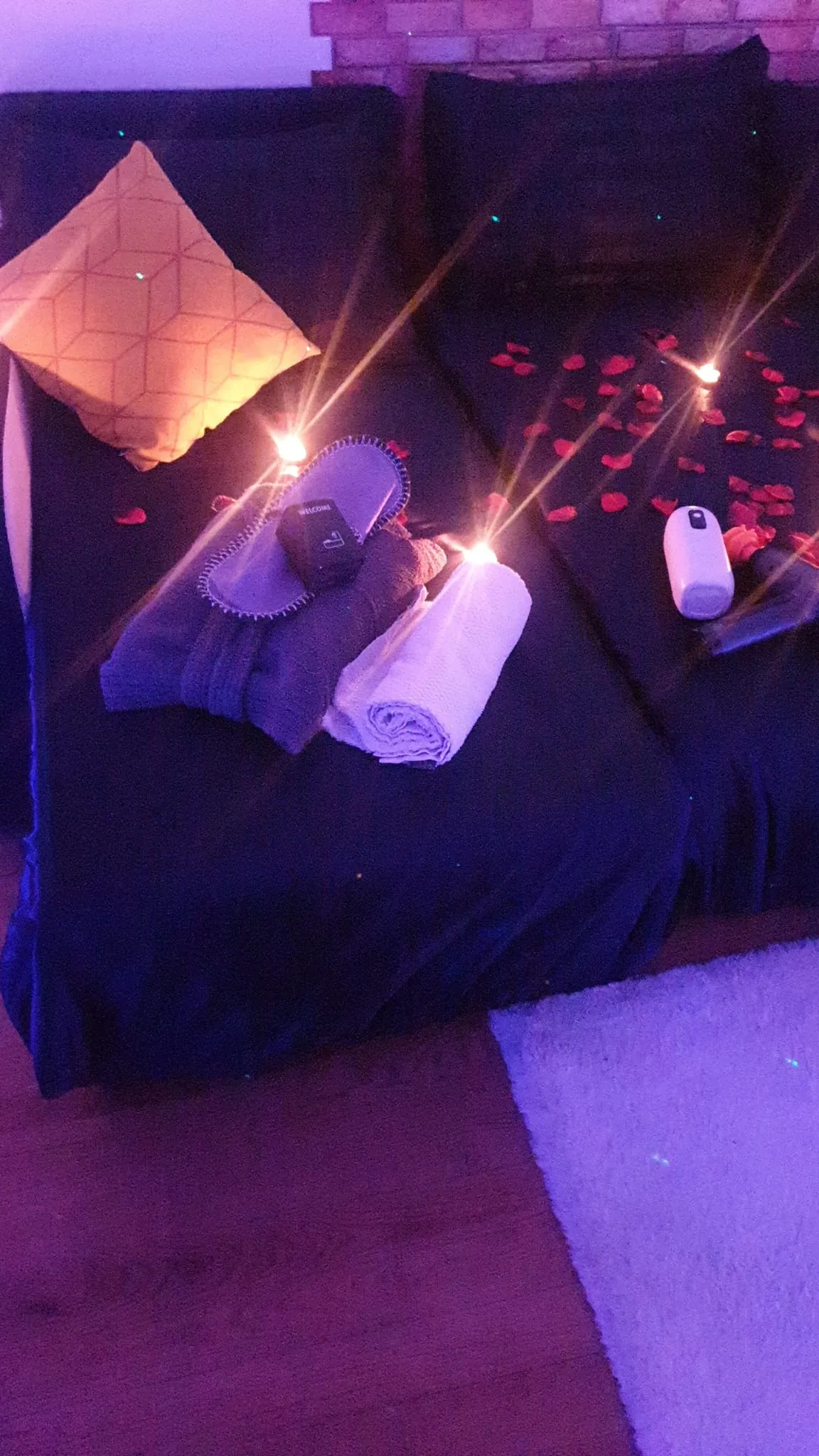 Chaussons de bienvenue et serviettes près de bougies
